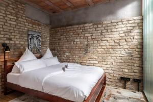 uma cama num quarto com uma parede de tijolos em Industrial 57sqm 3room maisonette apt near center em Berlim