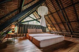 a bedroom with a bed in a thatched room at The Tropical Koh Mook in Ko Mook