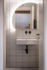y baño con lavabo y espejo. en Black White 44sqm 2room maisonette apt near center en Berlín