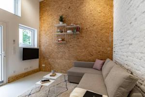 uma sala de estar com um sofá e uma parede de tijolos em Youngster 50sqm 4room maisonette apt near center em Berlim