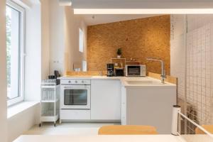 a kitchen with white appliances and a large window at Youngster 50sqm 4room maisonette apt near center in Berlin