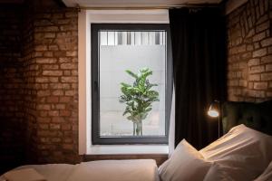 een slaapkamer met een raam met een plant in een vaas bij Ancient 33sqm 2room maisonette apt Near center in Berlijn