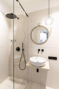 een badkamer met een wastafel en een douche met een spiegel bij Ancient 33sqm 2room maisonette apt Near center in Berlijn