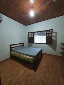 1 dormitorio con 1 cama en una habitación con techo de madera en Temporada piscina infantil, wifi e churrasqueira en Prado