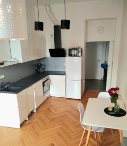 eine Küche mit weißen Schränken, einem Tisch und einem Esszimmer in der Unterkunft Harmony Residence One in Prag