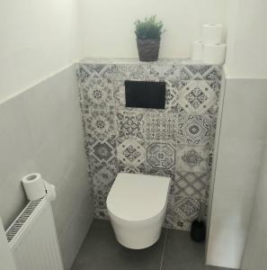 ein Bad mit einem WC und einer gefliesten Wand in der Unterkunft Harmony Residence One in Prag
