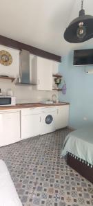 a white kitchen with a sink and a bed at Estudio LA paradise in Torremolinos
