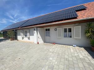 una casa con paneles solares en el techo en Itthon Vagy Vendégház 