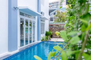 uma piscina no meio de um edifício em T-Maison Boutique Villa, with Pool, Karaoke, Billiards, near beach, Vung Tau em Vung Tau