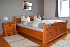 a bedroom with a large wooden bed with white pillows at Haus Sonnenblick in Benneckenstein