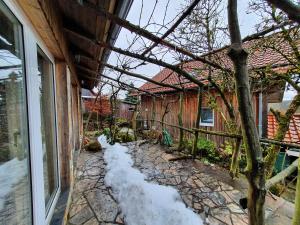 a house with snow on the ground next to a building at Haus Irina & Haus Anna in Elend