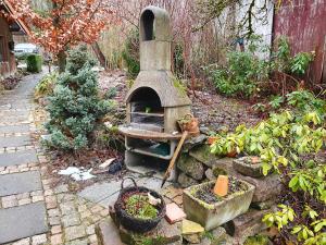 a garden with an outdoor oven with some plants at Haus Irina & Haus Anna in Elend