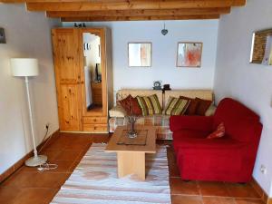a living room with a red couch and a table at Haus Irina & Haus Anna in Elend +39 photos