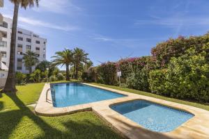 - une piscine dans une cour à côté d'un bâtiment dans l'établissement La Gavina Playa, à Jávea