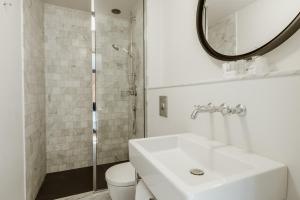 a white bathroom with a sink and a mirror at Auberge du Pêcheur in Sint-Martens-Latem