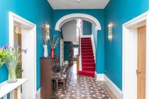 a hallway with blue walls and a red stairway at The Wenning in High Bentham