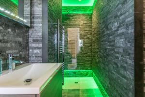 a bathroom with a bath tub and green tiles at The Wenning in High Bentham