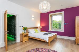 ein Schlafzimmer mit einem Bett und einer lila Wand in der Unterkunft The Wenning in High Bentham + 38 Fotos