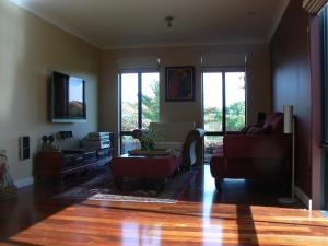 a living room with two couches and a table at Le Boulevard in Mindarie