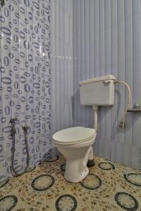 a bathroom with a toilet and a shower curtain at Hotel Raaj Inn in Calangute