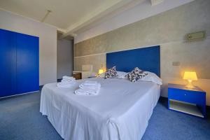 a bedroom with a large white bed with towels on it at HOTEL VITTORIA in Sirmione