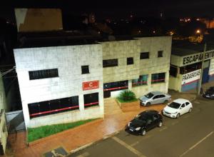 un estacionamiento con autos estacionados frente a un edificio en Hotel Castro, en Itumbiara