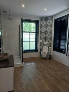 baño con aseo y lavabo y ventana en Slapen in een eeuwen oude Pastorie 