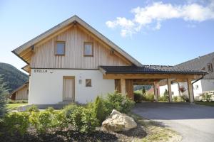 ein weißes Haus mit einem Holzdach in der Unterkunft Haus Stella in Mauterndorf