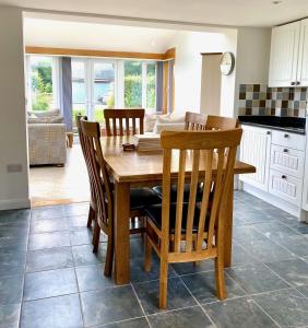 a kitchen and dining room with a wooden table and chairs at Badges Cottage for 5 Near Dartmoor Beaches and Pub in Holsworthy
