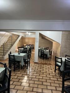a dining room with tables and chairs and a staircase at Hotel Castro in Itumbiara