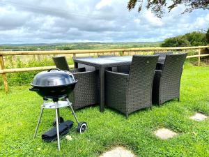 a grill sitting next to a table in the grass at Badges Cottage for 5 Near Dartmoor Beaches and Pub in Holsworthy