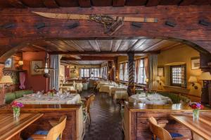 a restaurant with tables and chairs in a room at Hotel Chesa Grischuna in Klosters