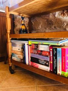 un estante lleno de libros sobre una mesa en Stonehouse dome Lagadia, en Lagadia