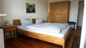 - un grand lit en bois dans une chambre avec une armoire en bois dans l'établissement Ferienwohnung Cecilia, à Meersburg