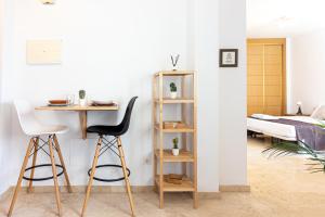Habitación con escritorio, 2 sillas y 1 cama. en San Rafael 3 RooMalaga by Bossh Apartments, en Málaga
