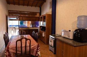 eine Küche mit einem Esstisch und einer Mikrowelle in der Unterkunft Estâncias da Serra dos Alves 2 in Itabira