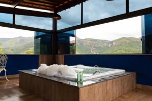 y baño con bañera y vistas a las montañas. en Estâncias da Serra dos Alves 2, en Itabira