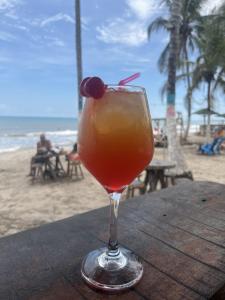 una bebida sentada en una mesa en la playa en PALOMINO PLAZA HOSTEL, en Palomino