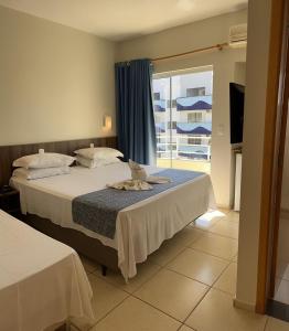 een hotelkamer met 2 bedden en een raam bij Hotel Villa das Termas in Marcelino Ramos
