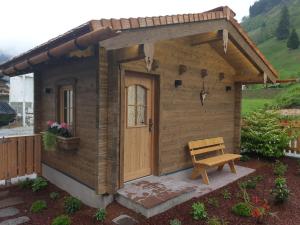 Cabaña de madera con banco en un patio en Hochalmbahnen Chalets Rauris 1-03 Maislaufeldweg 1c en Rauris