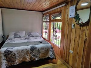 een slaapkamer met een bed en een raam bij Los Vagones de William in Tibasosa