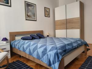 a bedroom with a bed with blue pillows on it at Grand Apartman San with garage in Sarajevo