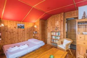 una camera con un letto in una stanza con pareti in legno di Chalet Bossons - Welkeys a Chamonix-Mont-Blanc