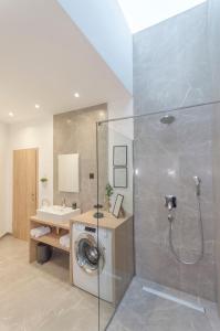 a bathroom with a shower and a washing machine at Villa Laurel in Skradin