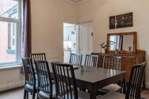 a dining room with a table and chairs and a mirror at Contractors accommodation in Chorley by Lancashire Holiday Lets in Chorley