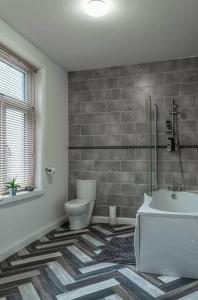 Contractors accommodation in Chorley by Lancashire Holiday Lets في تشورلي: حمام مع مرحاض ومغسلة وحوض استحمام