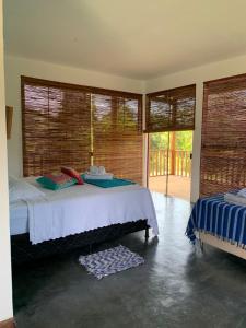 a bedroom with a bed and a large window at Pousada Flor do Rio in Caraíva