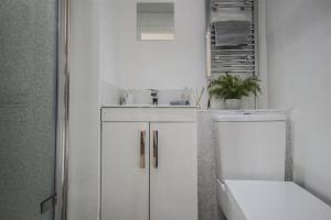 Baño blanco con lavabo y aseo en Contractors accommodation in Chorley by Lancashire Holiday Lets, en Chorley