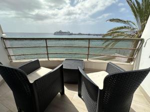 d'un balcon avec des chaises et une vue sur l'océan. dans l'établissement Paseo Marítimo, Los Cristianos Over the sea FREE WIFI, à Arona