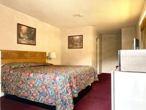 a hotel room with a bed and a refrigerator at Economy inn in Sweetwater